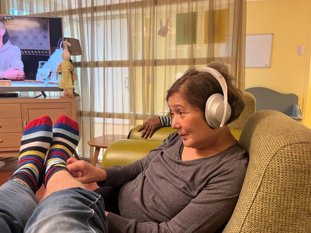 David and Grace watching TV and listening to music in the care home